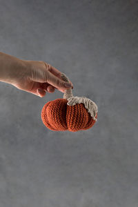 A woman's hand holds a knitted pumpkin. autumn and coziness. diy decor.