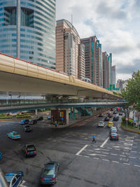 View of city street and modern buildings against sky