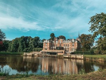 Lake by buildings against sky