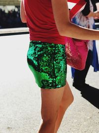 Midsection of woman wearing green sequin skirt while standing on street