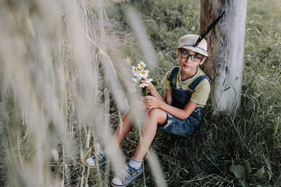 Portrait of young woman sitting on field