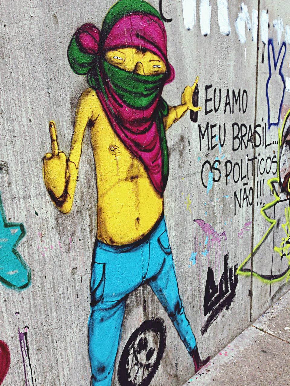 creativity, art and craft, text, art, graffiti, multi colored, wall - building feature, western script, communication, yellow, high angle view, wall, street art, day, human representation, blue, outdoors, no people, street, animal representation