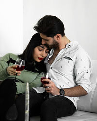 Young woman using mobile phone while sitting at home