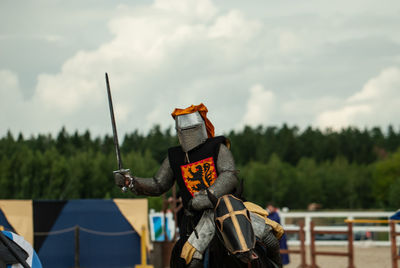 Knight holding sword riding on horse