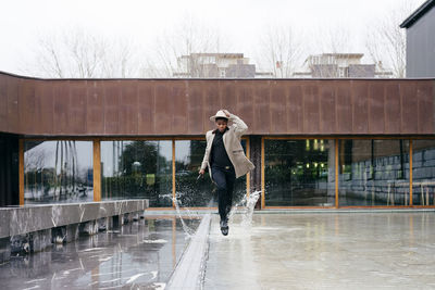 Full length of teenage girl standing in building during winter