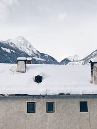 House on snowcapped mountains against sky