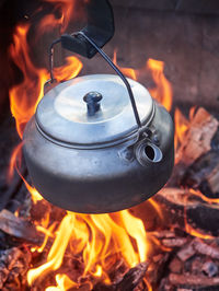 Close-up of teapot over bonfire
