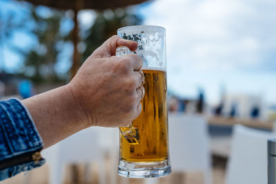 Close-up of hand holding beer glass