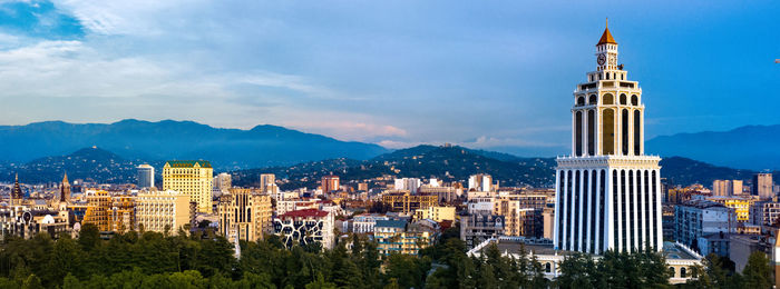 Buildings in city against cloudy sky