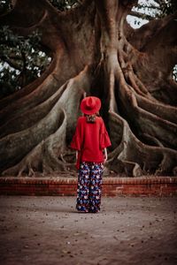 Rear view of woman standing by tree