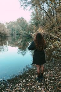 Full length of woman standing by lake