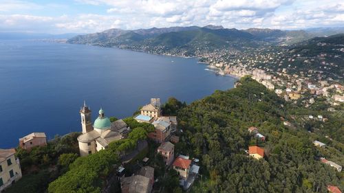 High angle view of town by sea against sky