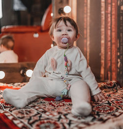 Cute girl playing with teddy bear on table