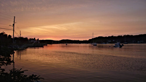 Boats in sea at sunset