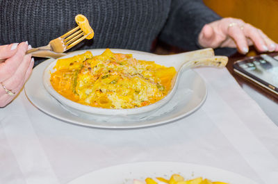 Woman using mobile phone while eating