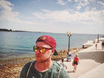 Man standing at beach against sky