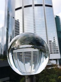 Close-up of crystal ball against building in city