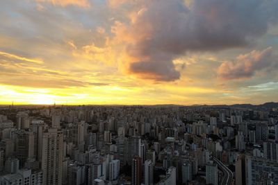 Aerial view of buildings against sky during sunset