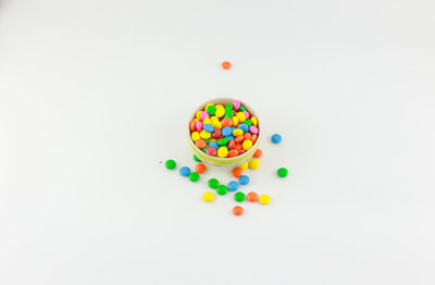 High angle view of multi colored candies against white background