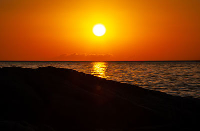 Scenic view of sea against orange sky