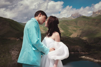 Love, wedding and married couple kissing by the lake outdoors in honor of their romantic marriage