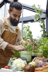 Side view of man picking vegetables