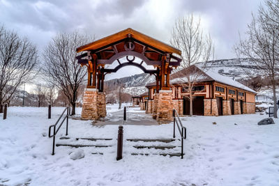 Built structure on snow covered field against sky