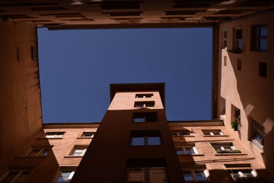 Low angle view of buildings against clear blue sky