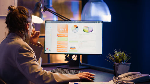 Midsection of woman using laptop on table