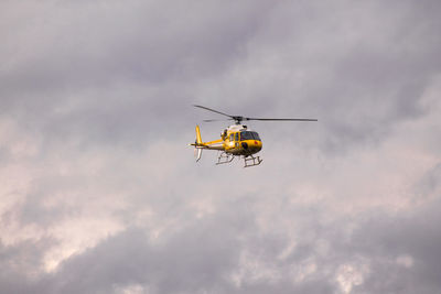 Low angle view of yellow helicopter against sky