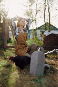 Side view of woman sitting on field