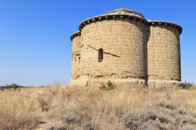 Low angle view of castle on field against clear sky