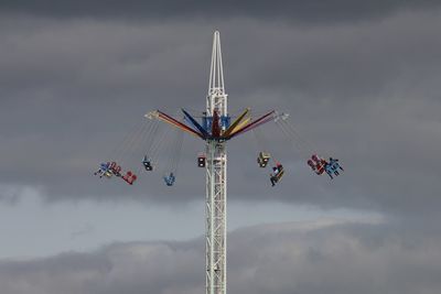 Low angle view of chain swing ride against sky