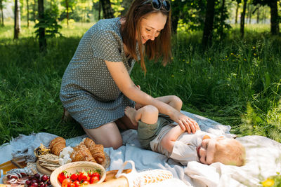 Family mom and son on picnic. smiling and enjoying summer on blanket in park.