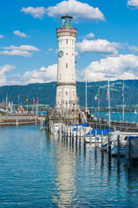 Lighthouse by sea against sky