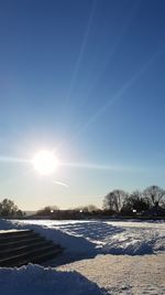 Snow on field against sky during winter