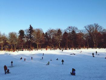 People skiing on snow covered landscape