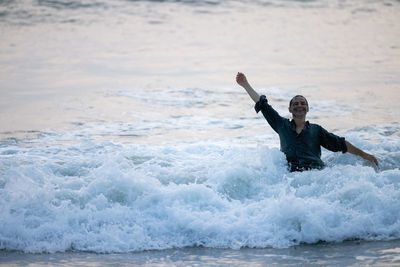 Rear view of man surfing in sea