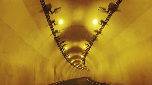 Low angle view of illuminated lighting equipment in tunnel