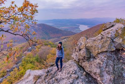 Full length of woman standing on mountain against sky