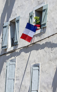 The facade of the building with the flags of france in the window.