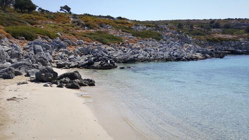 Rocks on beach against clear sky