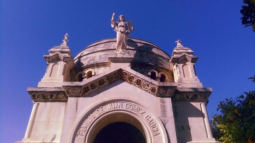 Low angle view of statue against blue sky