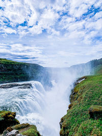 Scenic view of waterfall against sky