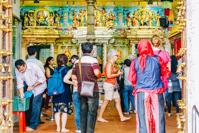 Rear view of people standing outside temple