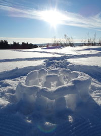 Scenic view of snow covered field against sky