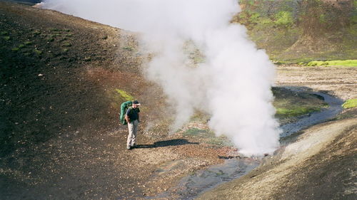 High angle view of male hiker looking at steam