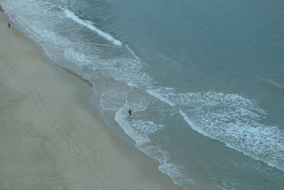 High angle view of waves rushing towards shore