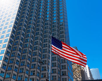 Low angle view of flag against modern building