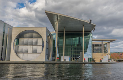 Building by river against sky